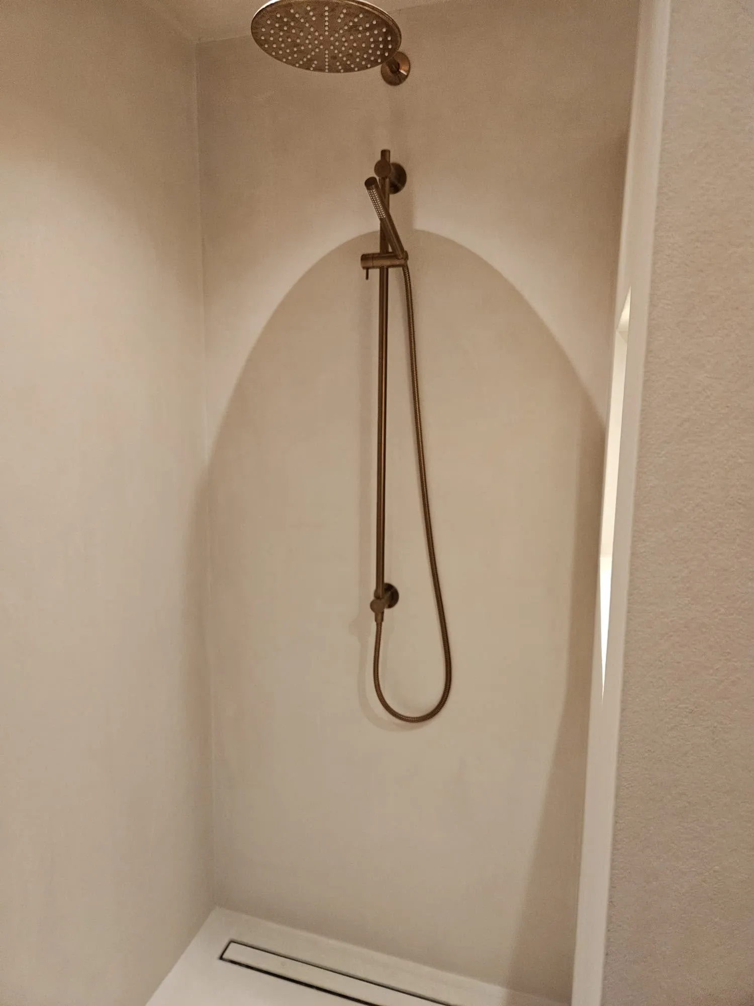 Douche in microcement met afschot naar een lange afvoergoot