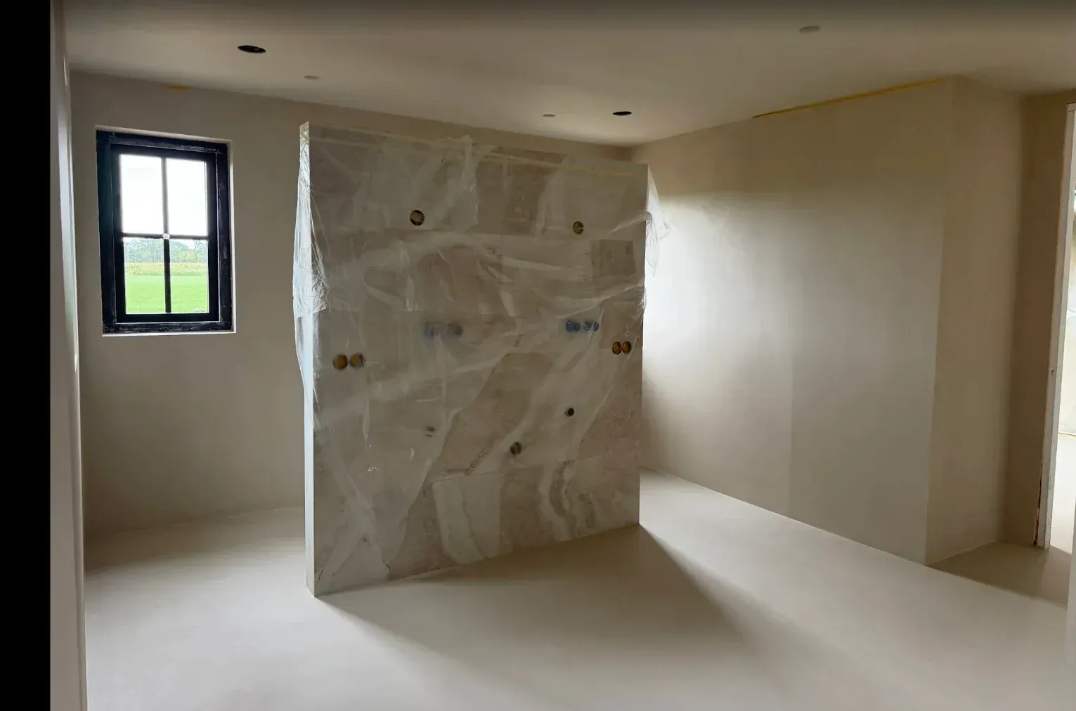Doorlopende lichte lavasteen vloer in een badkamer die aansluit op de begane grond in Epe