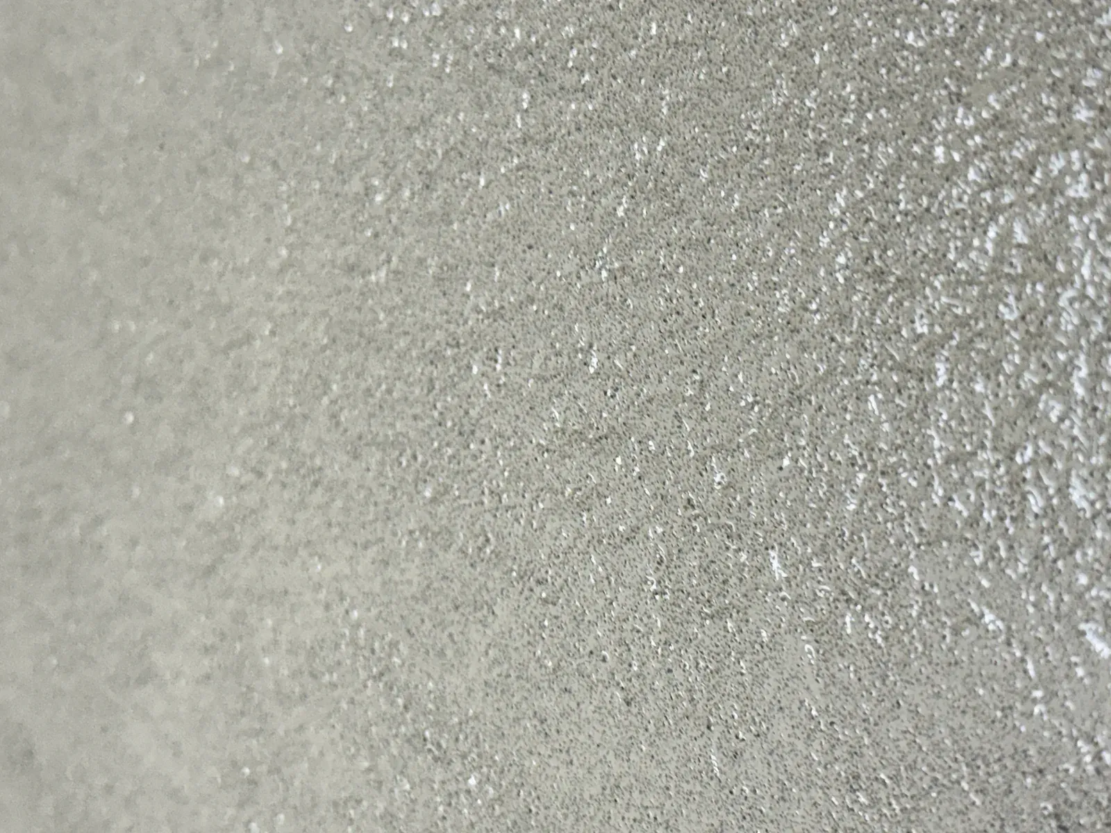 Close-up van een lichtgrijze lavasteen gietvloer met fijne minerale spikkeling