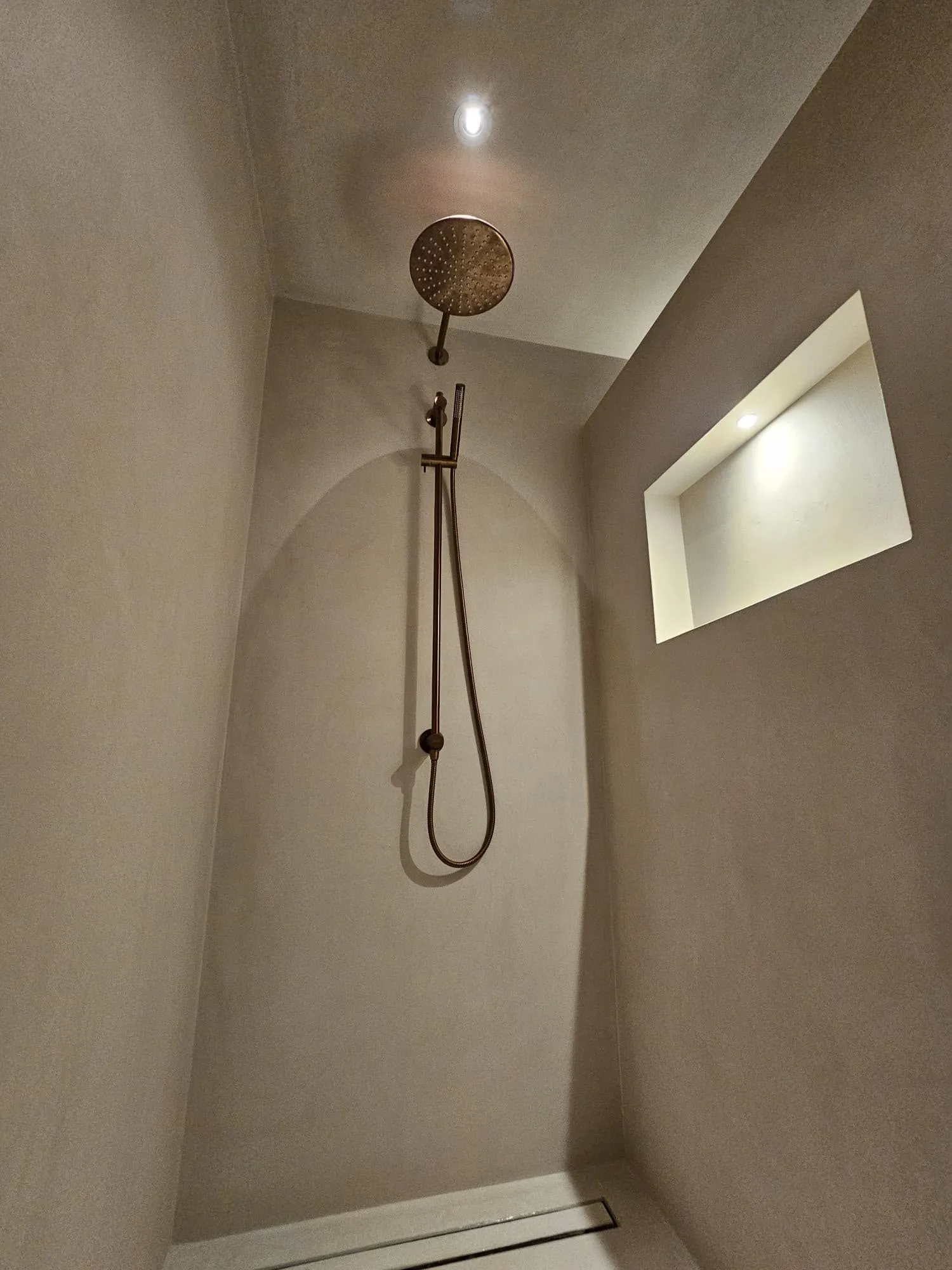 Douche in microcement met een verlichte nis