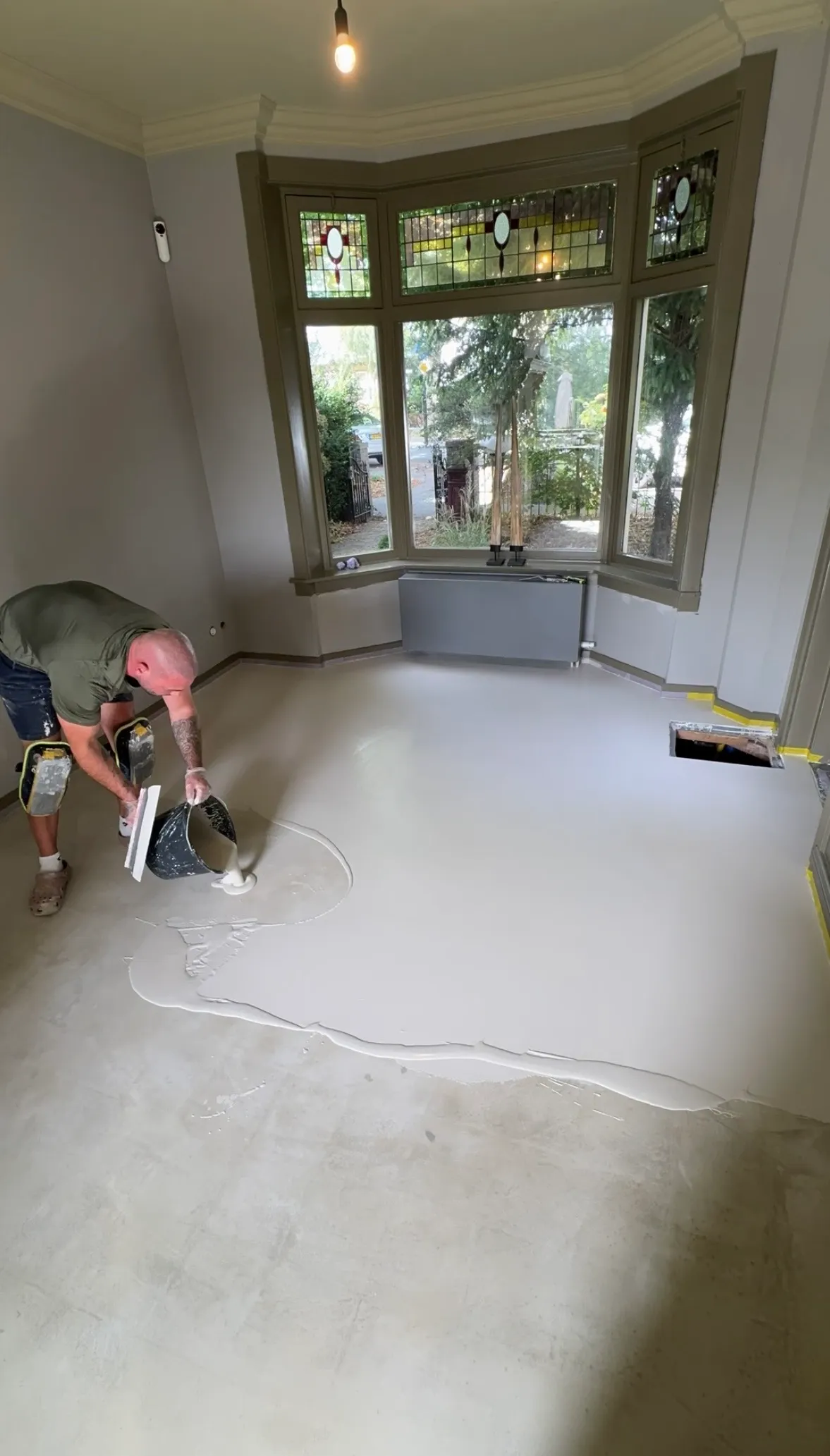 Tim giet de egaline over de oude plavuizen in de erker van de woonkeuken in Beverwijk