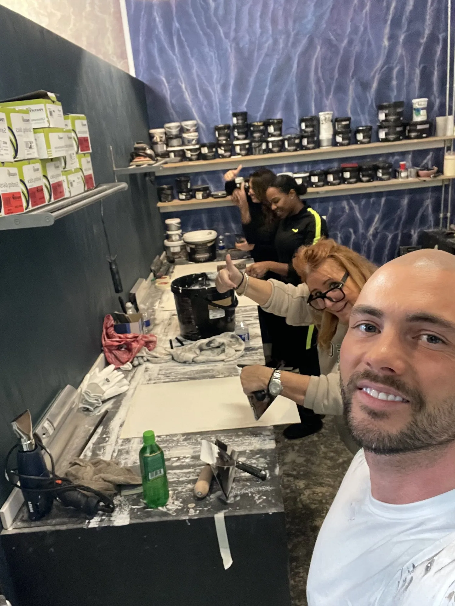 Tim met twee cursisten aan de werktafel, duim omhoog